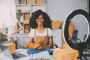 moda blogueiro conceito, jovem ásia mulheres vendendo roupas em streaming.startup pequeno o negócio sme, usando Smartphone ou tábua levando receber e verificação dentro escritório foto