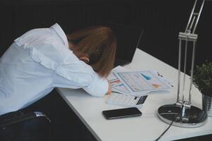 empresária bocejando enquanto trabalhando com uma computador portátil computador dentro a escritório, uma mulher dentro casual escritório estilo de vida conceito. foto