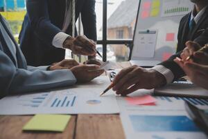 co conferência de trabalho, reunião da equipe de negócios presente, colegas investidores discutindo os dados do gráfico financeiro do novo plano na mesa do escritório com laptop e tablet digital, finanças, contabilidade, investimento. foto