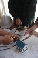 conceito de construção e estrutura de reunião de engenheiro ou arquiteto para projeto trabalhando com parceiros e ferramentas de engenharia na construção de modelo e projeto no local de trabalho, contrato para ambas as empresas. foto