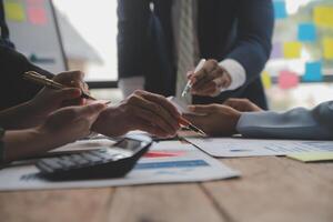 co conferência de trabalho, reunião da equipe de negócios presente, colegas investidores discutindo os dados do gráfico financeiro do novo plano na mesa do escritório com laptop e tablet digital, finanças, contabilidade, investimento. foto