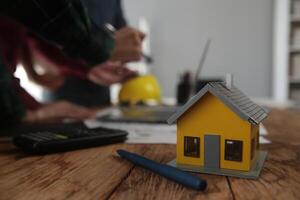 engenheiros estão consultando a equipe para Projeto a arquitetônico estrutura para clientes com plantas e construção modelos para trabalhos às escritório. foto