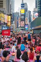 cidade de nova york, eua - 21 de junho de 2016. pessoas na concentração anual de ioga no solstício de verão na times square, símbolo icônico da cidade de nova york e dos estados unidos da américa foto