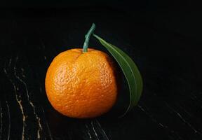 dois maduro suculento tangerinas em uma Preto fundo. foto