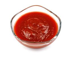 ketchup dentro uma vidro copo isolado em uma branco fundo. tomate molho . foto