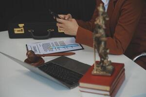 americano mulher advogado ou empresária africano trabalhando com computador portátil, procurando, analisando dados, lendo contrato documentos trabalhos com lei livros martelo do justiça consultando advogado conceito. foto