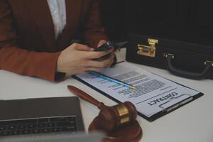 americano mulher advogado ou empresária africano trabalhando com computador portátil, procurando, analisando dados, lendo contrato documentos trabalhos com lei livros martelo do justiça consultando advogado conceito. foto