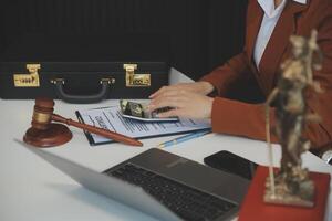 americano mulher advogado ou empresária africano trabalhando com computador portátil, procurando, analisando dados, lendo contrato documentos trabalhos com lei livros martelo do justiça consultando advogado conceito. foto