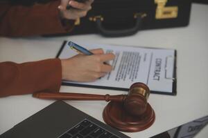 americano mulher advogado ou empresária africano trabalhando com computador portátil, procurando, analisando dados, lendo contrato documentos trabalhos com lei livros martelo do justiça consultando advogado conceito. foto