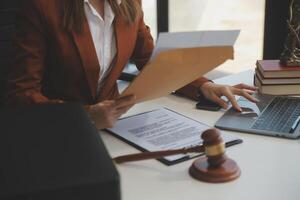 americano mulher advogado ou empresária africano trabalhando com computador portátil, procurando, analisando dados, lendo contrato documentos trabalhos com lei livros martelo do justiça consultando advogado conceito. foto