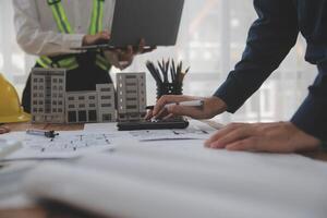 conceito de construção e estrutura de reunião de engenheiro ou arquiteto para projeto trabalhando com parceiros e ferramentas de engenharia na construção de modelo e projeto no local de trabalho, contrato para ambas as empresas. foto