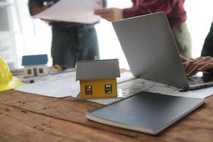 diverso equipe do especialistas usar computador portátil em construção local. real Estado construção projeto com engenheiro investidor e homem de negocios verificação área, trabalhando em Civil Engenharia, discutindo estratégia plano foto