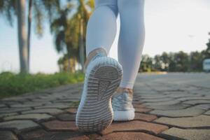 jovem ginástica mulher corredor alongamento pernas antes corre em cidade foto