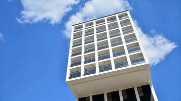 moderno apartamento edifícios em uma ensolarado dia com uma azul céu. fachada do uma moderno apartamento prédio. vidro superfície com luz solar. foto