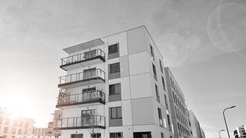 fragmento do a edifício de fachada com janelas e varandas. moderno apartamento edifícios em uma ensolarado dia. fachada do uma moderno residencial prédio. Preto e branco. foto