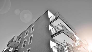 fragmento do a edifício de fachada com janelas e varandas. moderno apartamento edifícios em uma ensolarado dia. fachada do uma moderno residencial prédio. Preto e branco. foto