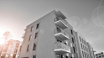 fragmento do a edifício de fachada com janelas e varandas. moderno apartamento edifícios em uma ensolarado dia. fachada do uma moderno residencial prédio. Preto e branco. foto