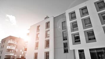 fragmento do a edifício de fachada com janelas e varandas. moderno apartamento edifícios em uma ensolarado dia. fachada do uma moderno residencial prédio. Preto e branco. foto