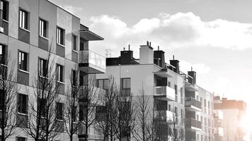 fragmento do a edifício de fachada com janelas e varandas. moderno apartamento edifícios em uma ensolarado dia. fachada do uma moderno residencial prédio. Preto e branco. foto