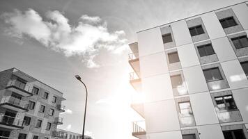 fragmento do a edifício de fachada com janelas e varandas. moderno apartamento edifícios em uma ensolarado dia. fachada do uma moderno residencial prédio. Preto e branco. foto