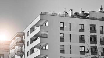 fragmento do a edifício de fachada com janelas e varandas. moderno apartamento edifícios em uma ensolarado dia. fachada do uma moderno residencial prédio. Preto e branco. foto