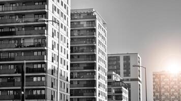 fragmento do a edifício de fachada com janelas e varandas. moderno apartamento edifícios em uma ensolarado dia. fachada do uma moderno residencial prédio. Preto e branco. foto