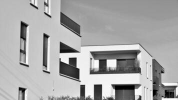 fragmento do a edifício de fachada com janelas e varandas. moderno apartamento edifícios em uma ensolarado dia. fachada do uma moderno residencial prédio. Preto e branco. foto