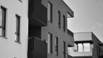 fragmento do a edifício de fachada com janelas e varandas. moderno apartamento edifícios em uma ensolarado dia. fachada do uma moderno residencial prédio. Preto e branco. foto