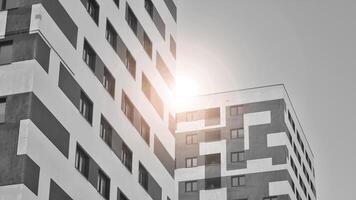 fragmento do a edifício de fachada com janelas e varandas. moderno apartamento edifícios em uma ensolarado dia. fachada do uma moderno residencial prédio. Preto e branco. foto