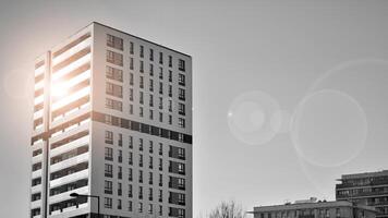 fragmento do a edifício de fachada com janelas e varandas. moderno apartamento edifícios em uma ensolarado dia. fachada do uma moderno residencial prédio. Preto e branco. foto