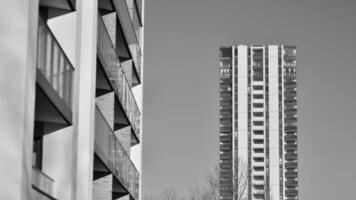 fragmento do a edifício de fachada com janelas e varandas. moderno apartamento edifícios em uma ensolarado dia. fachada do uma moderno residencial prédio. Preto e branco. foto