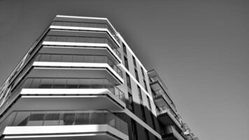 fragmento do a edifício de fachada com janelas e varandas. moderno apartamento edifícios em uma ensolarado dia. fachada do uma moderno residencial prédio. Preto e branco. foto