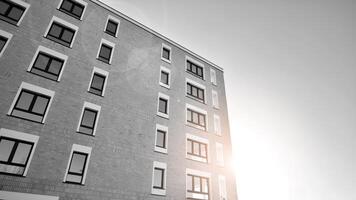 fragmento do a edifício de fachada com janelas e varandas. moderno apartamento edifícios em uma ensolarado dia. fachada do uma moderno residencial prédio. Preto e branco. foto