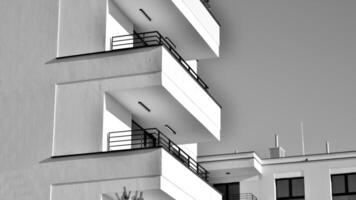 fragmento do a edifício de fachada com janelas e varandas. moderno apartamento edifícios em uma ensolarado dia. fachada do uma moderno residencial prédio. Preto e branco. foto