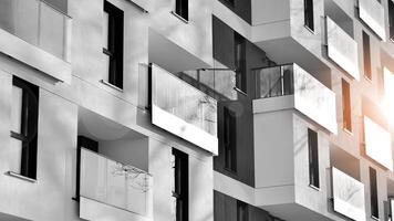 fragmento do a edifício de fachada com janelas e varandas. moderno apartamento edifícios em uma ensolarado dia. fachada do uma moderno residencial prédio. Preto e branco. foto