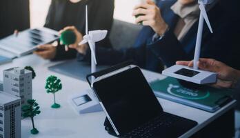 eco o negócio companhia encontro com grupo do o negócio pessoas usando computador portátil para plano estratégia e discutir marketing do ecológico e limpar \ limpo energia produtos. verde o negócio companhia conceito. pioneirismo foto