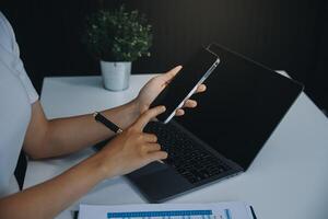 mulher asiática feliz animada olhando para a tela do telefone, comemorando uma vitória online, jovem mulher asiática muito feliz gritando de alegria, isolada sobre um fundo branco desfocado foto