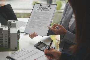o negócio assinatura uma contrato Comprar - vender casa, seguro agente analisando sobre casa investimento empréstimo real Estado conceito. foto
