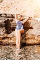 mulher viagem verão mar. uma feliz turista dentro uma azul bikini desfrutando a cênico Visão do a mar e vulcânico montanhas enquanto levando As fotos para capturar a recordações do dela viagem aventura.