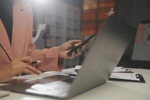 trabalho usando telefone celular digitando computador laptop de bate-papo móvel entre em contato conosco em locais de trabalho, planejando ideias investidores pesquisando na internet, ideias conectando pessoas. foto