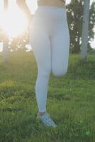 jovem ginástica mulher corredor alongamento pernas antes corre em cidade foto