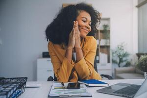 foto do bonita jovem menina sentar Área de Trabalho pc aguarde caneta escrever bloco de anotações vestem óculos camisa dentro casa escritório dentro de casa