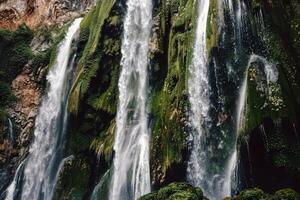 majestoso cascata em cascata baixa coberto de musgo pedras para dentro refrescante piscina abaixo foto