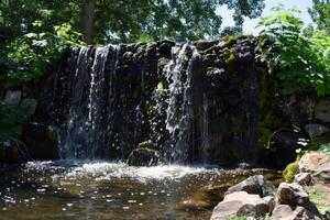 majestoso cascata em cascata baixa coberto de musgo pedras para dentro refrescante piscina abaixo foto