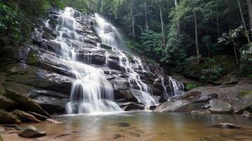 majestoso cascata em cascata baixa coberto de musgo pedras para dentro refrescante piscina abaixo foto