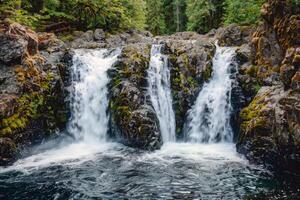 majestoso cascata em cascata baixa coberto de musgo pedras para dentro refrescante piscina abaixo foto