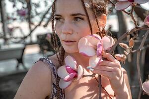 magnólia flores feliz mulher goza de florescendo magnólia árvore e cheira isto flores com fechadas olhos dentro Primavera jardim. retrato. foto