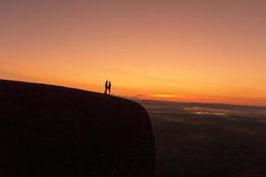 silhueta casal tão doce em pé na colina ao nascer do sol, hora da manhã em bueng kan tailândia. foto