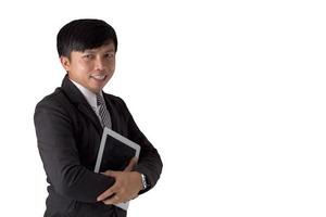 retrato asiático jovem vestindo terno segurando o tablet e sorrindo sobre fundo branco isolado. foto