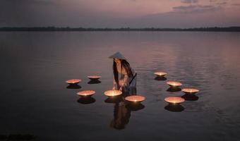 vietnamita em ao dai vietnam vestido tradicional no lago pôr do sol com lâmpada foto